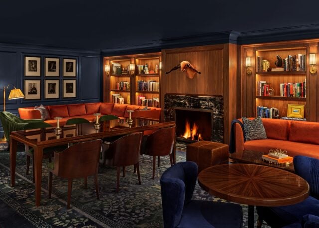 library with blue walls, a wooden dining table, and orange couches